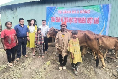 Thầy Vũ Văn Tùng (thứ 5 từ trái sang) phối hợp với Ban Giám hiệu Trường Tiểu học và THCS Lê Văn Tám trao sinh kế cho 2 học sinh nghèo vượt khó của trường. Ảnh: NVCC