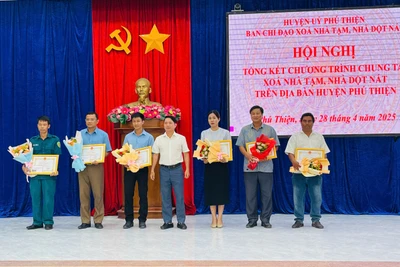 Ông Trần Trung Hiếu (đứng giữa, Bí thư Huyện ủy, Trưởng ban Chỉ đạo xóa nhà tạm, nhà dột nát huyện) tặng giấy khen cho các tập thể có thành tích xuất sắc trong thực hiện phong trào xóa nhà tạm, nhà dột nát trên địa bàn huyện. Ảnh: Vũ Chi