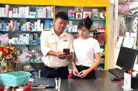 Cán bộ Thuế cơ sở 9 đồng hành, hỗ trợ hộ kinh doanh trong quá trình sử dụng eTax Mobile. Ảnh: Sơn Ca