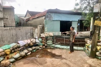 Các hộ dân ở cuối hẻm 280 Trường Chinh (phường Hội Phú) phải dùng bao cát, ván gỗ che chắn trước cửa để chống ngập. Ảnh: L.N
