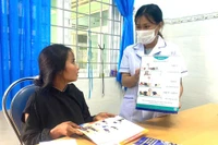 Nhân viên Trạm Y tế xã Lơ Pang hướng dẫn cho phụ nữ mang thai cách chăm sóc thai và khám thai định kỳ. Ảnh: Thu Loan