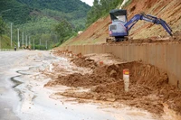 Lực lượng chức năng huy động phương tiện khắc phục sạt lở trên tuyến đường tránh phía Nam thị trấn Phú Phong.