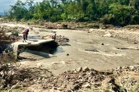 Nước lũ cuốn trôi khoảng 120 m đường bê tông dẫn vào làng Hrách (xã Sró) khiến giao thông bị chia cắt. Ảnh: Minh Phương