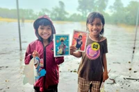 Các em nhỏ mỉm cười hạnh phúc khi nhận những bức hình đầu tiên của mình. Ảnh: Ngọc Duy