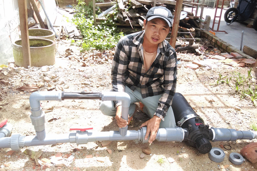 Anh Trạng đang lắp đặt hệ thống nước tưới nhỏ giọt cho bà con nông dân. Ảnh: P.L Anh Trạng đang lắp đặt hệ thống nước tưới nhỏ giọt cho bà con nông dân. Ảnh: P.L