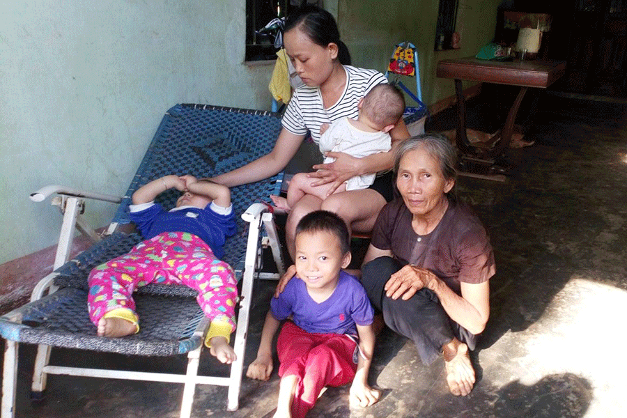 Bà Võ Thị Xô cùng con dâu chăm sóc 2 cháu bị nhiễm chất độc da cam. Ảnh: L.H.H