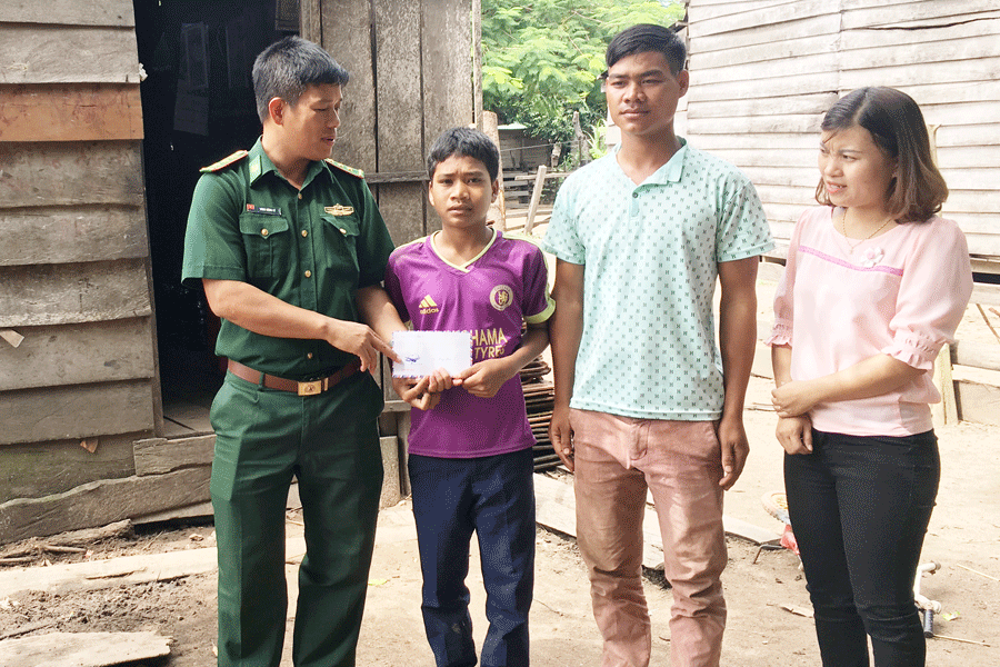 Đại diện Cụm Cơ động huấn luyện chó nghiệp vụ đến thăm và tặng quà em Rơ Mah Kim. Ảnh: L.H