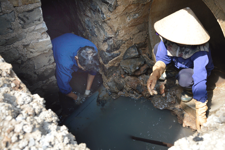 Các công nhân Công ty cổ phần Công trình Đô thị Gia Lai thực hiện nạo vét cống tại ngã tư Võ Thị Sáu-Hùng Vương (TP. Pleiku). Ảnh: L.L