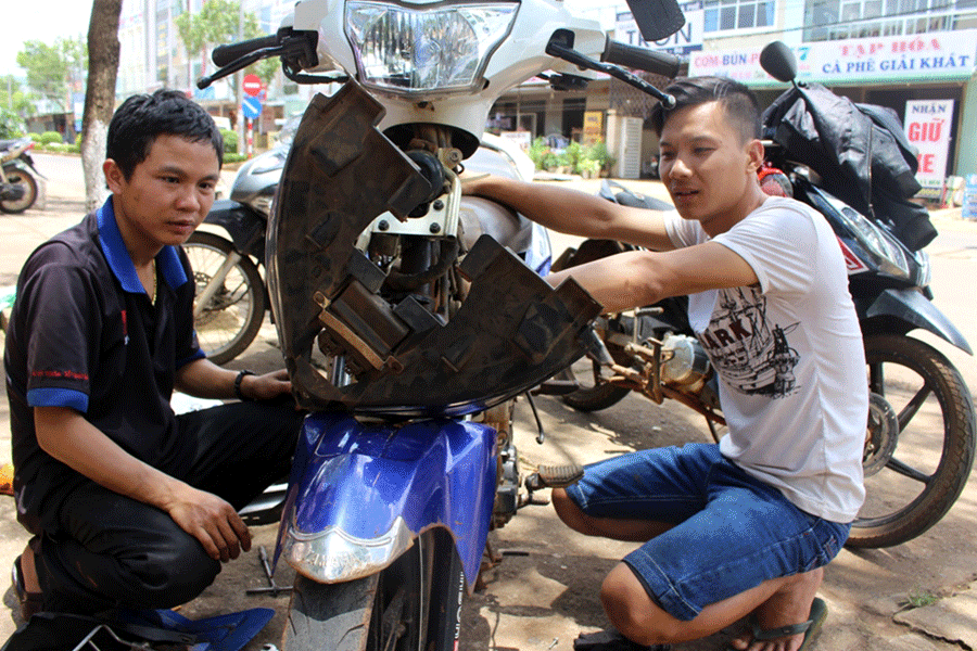 Anh Nguyễn Văn Long (bên phải) lập nghiệp với nghề sửa chữa xe máy. Ảnh: P.L