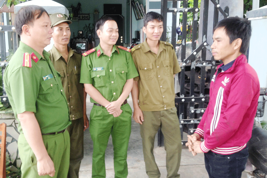 Cán bộ Công an huyện và Công an xã trao đổi thông tin với anh Nguyễn Văn Cường. Ảnh: M.L