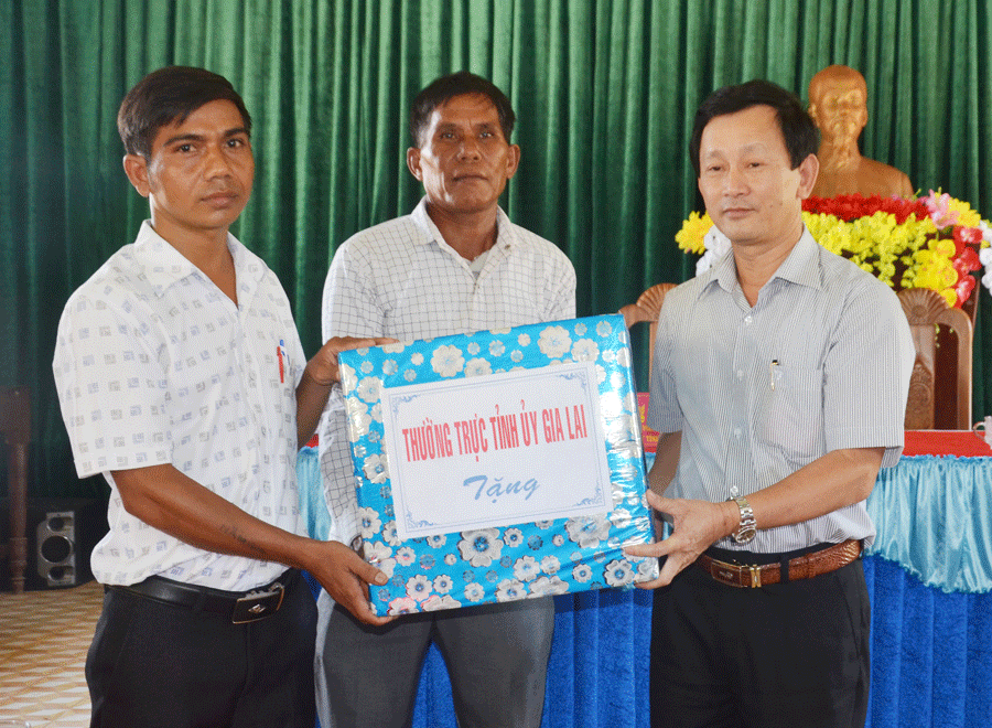 Bí thư Tỉnh ủy Dương Văn Trang (bên phải) tặng quà cho cán bộ làng Me. Ảnh: V.H