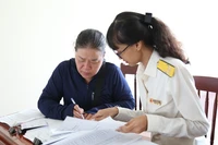 Công chức Thuế cơ sở 1 tư vấn, hướng dẫn hộ kinh doanh chuyển đổi từ phương pháp khoán sang phương pháp kê khai. Ảnh: T.SỸ