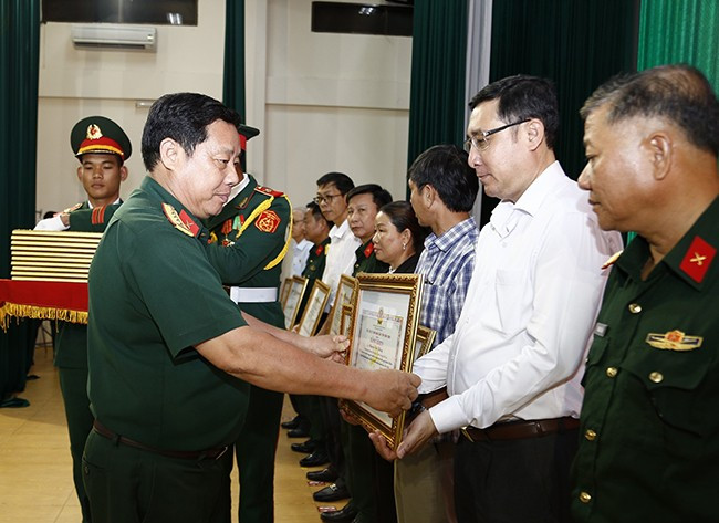 Đại tá Nguyễn Xuân Sơn trao bằng khen của UBND tỉnh cho các tập thể và cá nhân có thành tích xuất sắc trong việc thực hiện nhiệm vụ tìm kiếm, quy tập HCLS và xác định danh tính HCLS còn thiếu thông tin giai đoạn 2021 - 2025. Ảnh: H.P