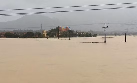 Nhà dân nằm ven Quốc lộ 19 bị nước lũ bao vây. Ảnh: H.Phúc