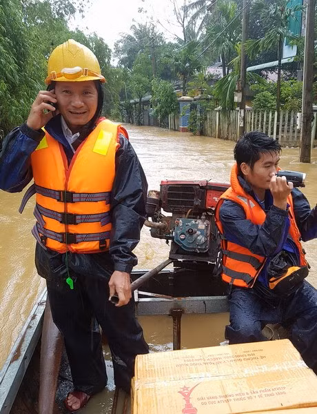 Chuyển hàng cứu trợ mì tôm và nước uống vào tận nhà dân thôn Vĩnh Phụng 1, xã Hoài Xuân. Ảnh: Tấn Đạt