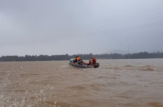 Huy động lực lượng công an vượt qua biển nước vận chuyển hàng cứu trợ đến thôn Vĩnh Phụng 2, xã Hoài Xuân. Ảnh: Tấn Đạt