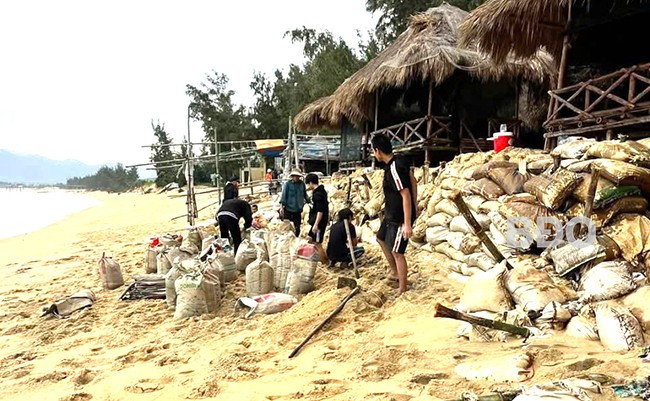 Người dân dùng bao cát, đá chẻ để chắn sóng các đoạn xung yếu có nguy cơ ảnh hưởng hộ dân dọc bờ biển tại khu phố An Quang Đông.