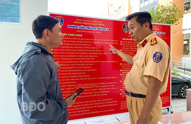 Trung tá Nguyễn Thanh Hoài, cán bộ Đội Sát hạch, cấp GPLX cơ giới đường bộ (Phòng CSGT - CA tỉnh) hướng dẫn người dân đổi GPLX qua dịch vụ công trực tuyến. Ảnh: N.C