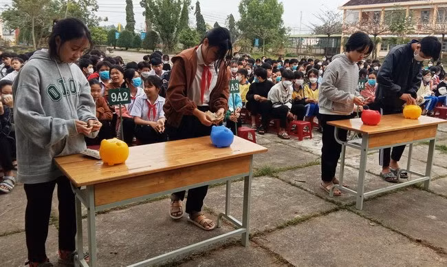 Học sinh Trường THCS Nhơn Thọ (TX An Nhơn) hào hứng cho heo đất “ăn”. Ảnh: Liên đội Trường THCS Nhơn Thọ