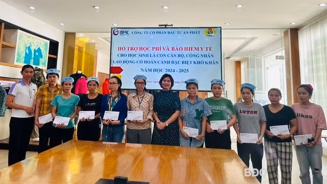 Lãnh đạo Công đoàn công ty trao tiền hỗ trợ thẻ BHYT và học phí cho phụ huynh học sinh. Ảnh: Công ty cung cấp.