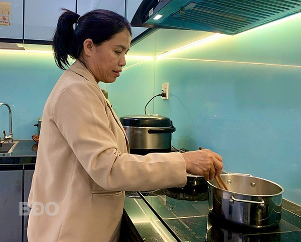 Bà Phạm Thị Liên tranh thủ nấu bữa trưa cho gia đình. Ảnh: T.K