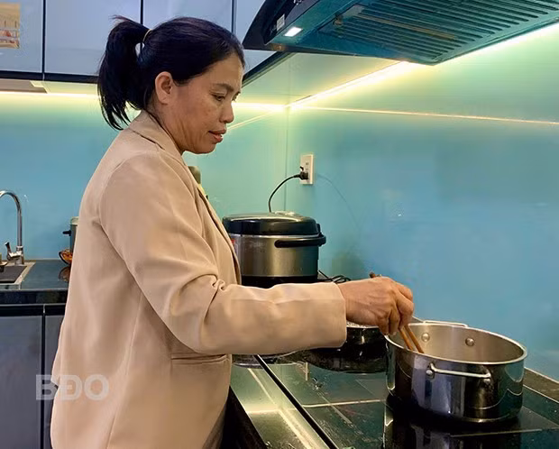 Bà Phạm Thị Liên tranh thủ nấu bữa trưa cho gia đình. Ảnh: T.K