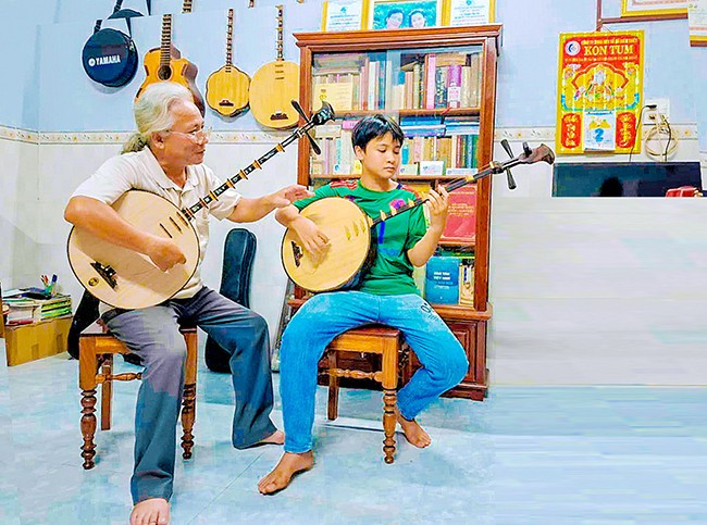 Nghệ nhân Ưu tú Lý Thành Long (bìa trái) dạy con trai đàn nguyệt. Ảnh: NGỌC NHUẬN Nghệ nhân Ưu tú Lý Thành Long (bìa trái) dạy con trai đàn nguyệt. Ảnh: NGỌC NHUẬN