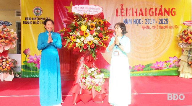 Phó Chủ tịch HĐND tỉnh Huỳnh Thúy Vân (bên trái) tặng hoa chúc mừng thầy và trò Trường Tiểu học Số 1 Ngô Mây trong lễ khai giảng. Ảnh: TRƯỜNG GIANG Phó Chủ tịch HĐND tỉnh Huỳnh Thúy Vân (bên trái) tặng hoa chúc mừng thầy và trò Trường Tiểu học Số 1 Ngô Mây trong lễ khai giảng. Ảnh: TRƯỜNG GIANG