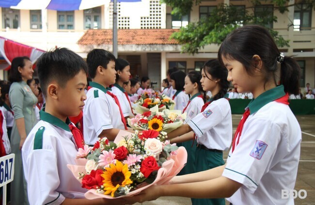 Đại diện học sinh lớp 9 tặng hoa chúc mừng học sinh lớp 6 vào trường học tập. Ảnh: TRỌNG LỢI Đại diện học sinh lớp 9 tặng hoa chúc mừng học sinh lớp 6 vào trường học tập. Ảnh: TRỌNG LỢI
