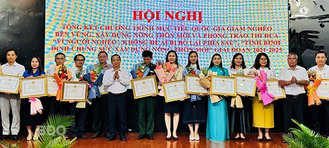 Phó Chủ tịch Thường trực UBND tỉnh Nguyễn Tuấn Thanh (thứ 6 từ trái sang) trao bằng khen cho các tập thể, cá nhân đạt thành tích xuất sắc trong Chương trình mục tiêu quốc gia giảm nghèo bền vững và phong trào thi đua. Ảnh: D.Đ