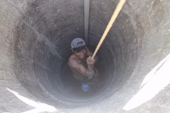 Anh thợ đào Huỳnh Thúc Cường đu dây thoát khỏi đáy giếng.