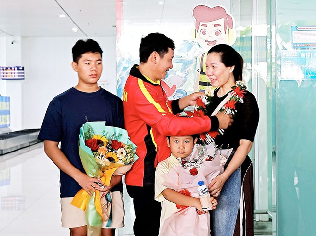 Gia đình HLV Trần Đình Đô đón anh trở về sau khi hoàn thành nhiệm vụ tại Giải vô địch kickboxing châu Á năm 2024. Ảnh: K.VY
