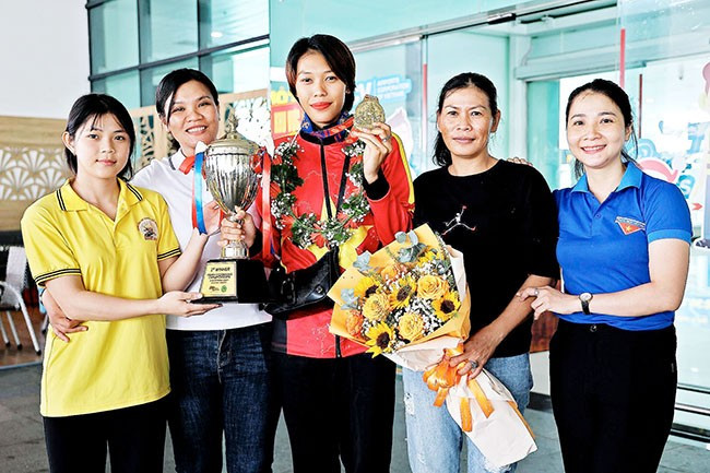 Trên con đường chinh phục những tấm huy chương, Trần Võ Song Thương (giữa) không quên người dẫn dắt mình vào con đường võ thuật - HLV La Thị Trụ (thứ 2 từ trái sang) và sự cổ vũ của mẹ (thứ 2 từ phải sang). Ảnh: K.VY