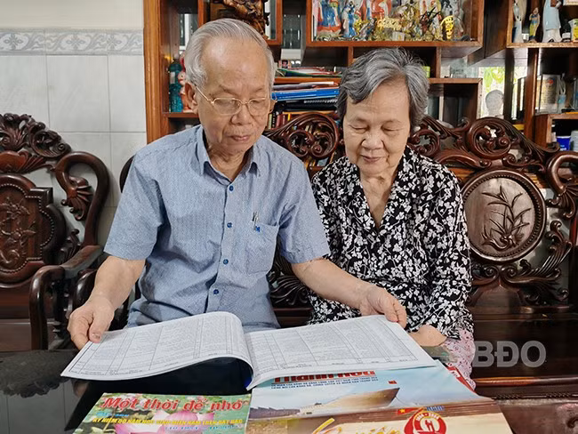 Vợ chồng ông Huỳnh Đăng Khanh đang xem lại sổ ghi chép thông tin về học sinh miền Nam sống tại Bình Định. Ảnh: H.THU