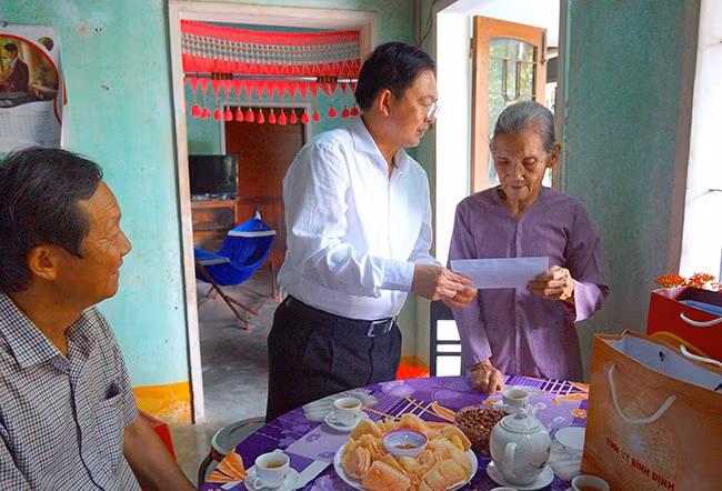 Bí thư Tỉnh ủy Hồ Quốc Dũng tặng quà, động viên cụ bà Nguyễn Thị Yên - mẹ liệt sĩ, bản thân là thương binh, cựu tù chính trị. Ảnh: N.M.