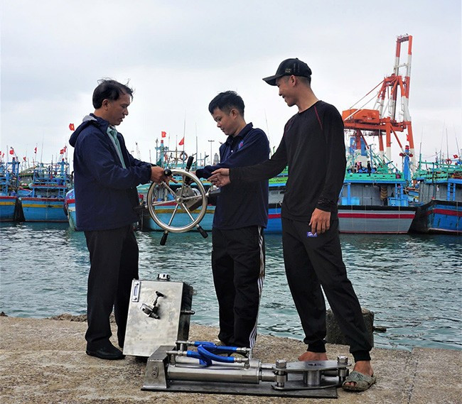 Anh Lê Tấn Thêm (bên trái) hướng dẫn anh Nguyễn Xuân Khánh (chủ tàu BĐ 91586 TS) cách sử dụng ty xi lanh thủy lực. Ảnh: HƯƠNG GIANG Anh Lê Tấn Thêm (bên trái) hướng dẫn anh Nguyễn Xuân Khánh (chủ tàu BĐ 91586 TS) cách sử dụng ty xi lanh thủy lực. Ảnh: HƯƠNG GIANG