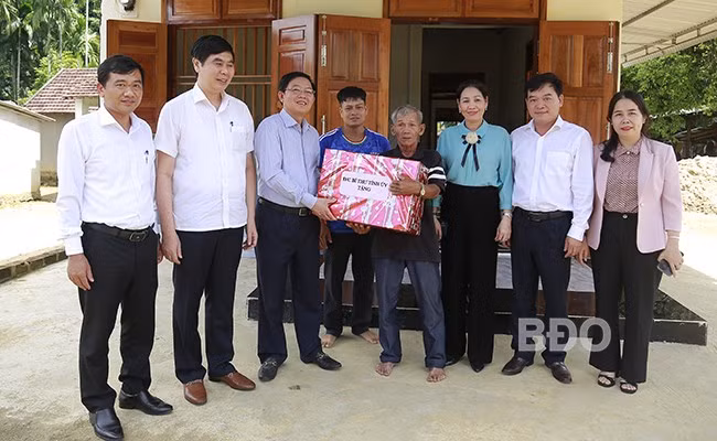 Bí thư Tỉnh ủy Hồ Quốc Dũng (thứ 3 từ trái sang) đến thăm, tặng quà gia đình ông Đinh Văn Túc (hộ nghèo, ở khu phố 2, thị trấn An Lão, huyện An Lão).