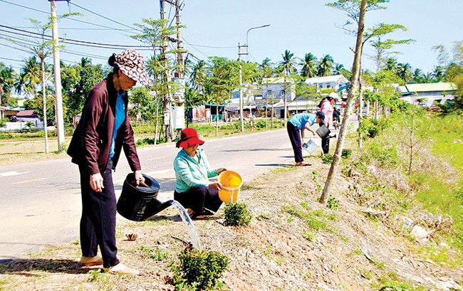 Phụ nữ phường Hoài Hương thay phiên chăm sóc cây xanh. Ảnh: TÀI NGÂN