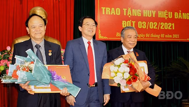 Đồng chí Hồ Quốc Dũng - Ủy viên Trung ương Đảng, Bí thư Tỉnh ủy, Chủ tịch HĐND tỉnh trao Huy hiệu Đảng cho đồng chí Nguyễn Tấn Hiểu và đồng chí Nguyễn Văn Thiện.