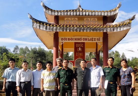 Thiếu tướng Nguyễn Trọng Huy (thứ 4, phải qua) cùng các đồng đội, người nhà 2 liệt sĩ tại Nghĩa trang liệt sĩ Hoài Hảo (Hoài Nhơn).