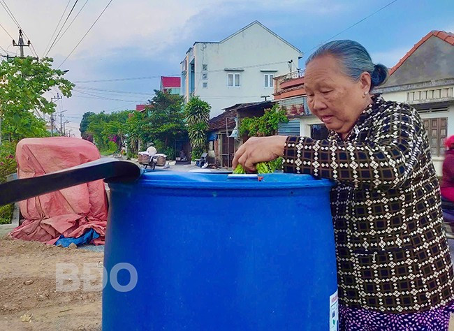 Bà Đỗ Thị Bích Hoa (thôn Định Thiện Đông, xã Phước Quang, huyện Tuy Phước) ủ phân bằng rác thải hữu cơ tại thùng ủ do Hội LHPN xã Phước Quang đặt. Ảnh: T.K