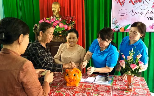 Chị Hoàng (thứ 2, từ phải sang) cùng người dân khu phố An Phú bỏ tiền vào heo đất, giúp người có hoàn cảnh khó khăn. Ảnh: NVCC