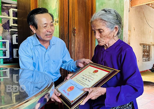 Phó Chủ tịch Thường trực HĐND tỉnh Đoàn Văn Phi tặng quà, thiếp mừng thọ của Chủ tịch UBND tỉnh cho cụ Ngô Thị Tiến. Ảnh: D.Đ