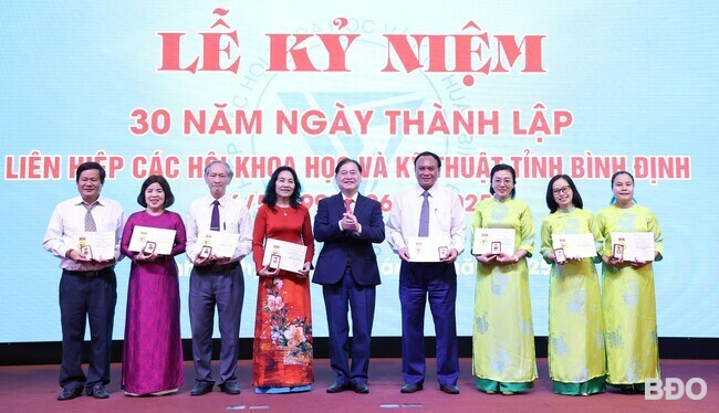 Đồng chí Phan Xuân Dũng, Chủ tịch Liên hiệp các hội KHKT Việt Nam tặng Kỷ niệm chương “Vì sự nghiệp các hội KHKT” cho 8 cá nhân tiêu biểu của Liên hiệp các hội KHKT Bình Định đã có nhiều đóng góp tích cực cho sự phát triển của hệ thống Liên hiệp hội. Ảnh: T.LỢI