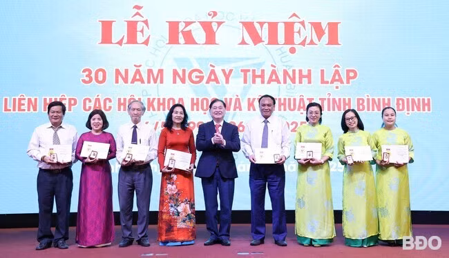 Đồng chí Phan Xuân Dũng, Chủ tịch Liên hiệp các hội KHKT Việt Nam tặng Kỷ niệm chương “Vì sự nghiệp các hội KHKT” cho 8 cá nhân tiêu biểu của Liên hiệp các hội KHKT Bình Định đã có nhiều đóng góp tích cực cho sự phát triển của hệ thống Liên hiệp hội. Ảnh: T.LỢI