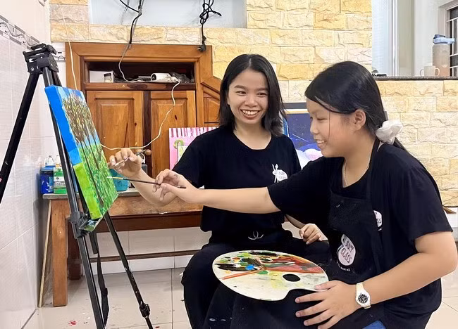 Chị Hồng hướng dẫn bé Hân hoàn thiện một bức tranh. Ảnh: T.H Chị Hồng hướng dẫn bé Hân hoàn thiện một bức tranh. Ảnh: T.H