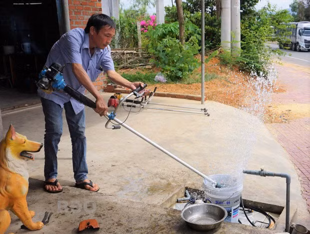 Anh Đặng Ngọc Vinh giới thiệu chiếc lồng chụp và chức năng gặt lúa từ chiếc máy cắt cỏ do anh cải tiến.