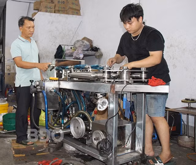 Ông Lê Tấn Thêm (bên trái) cho biết, ngoại trừ máy lái tự động được sản xuất tại Úc, các thiết bị để hoàn chỉnh bộ lái thủy lực tàu thuyền (có điều khiển remote) đều do công ty sản xuất. Ảnh: AN NHIÊN