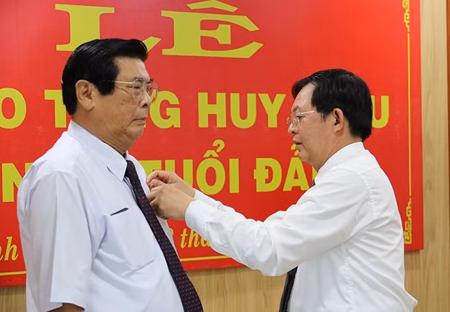 Bí thư Tỉnh ủy Hồ Quốc Dũng trao tặng Huy hiệu 50 năm tuổi Đảng cho đồng chí Vũ Hoàng Hà. Ảnh: H.THU