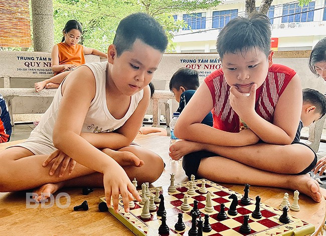 Cao Hữu Phước (trái, lớp 5H, Trường Tiểu học Lê Hồng Phong, TP Quy Nhơn) say sưa chơi cờ vua cùng bạn bè. Ảnh: D.L